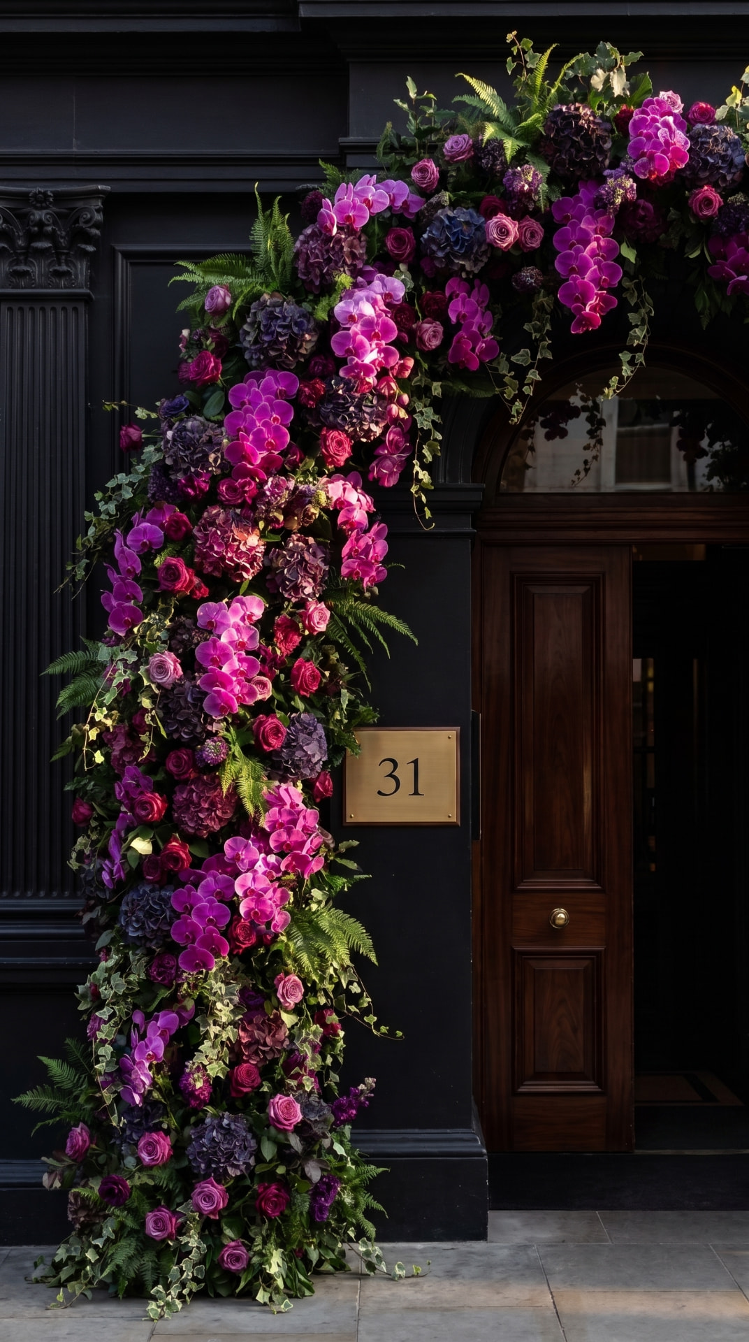 Pink and purple floral archway over a black townhouse door