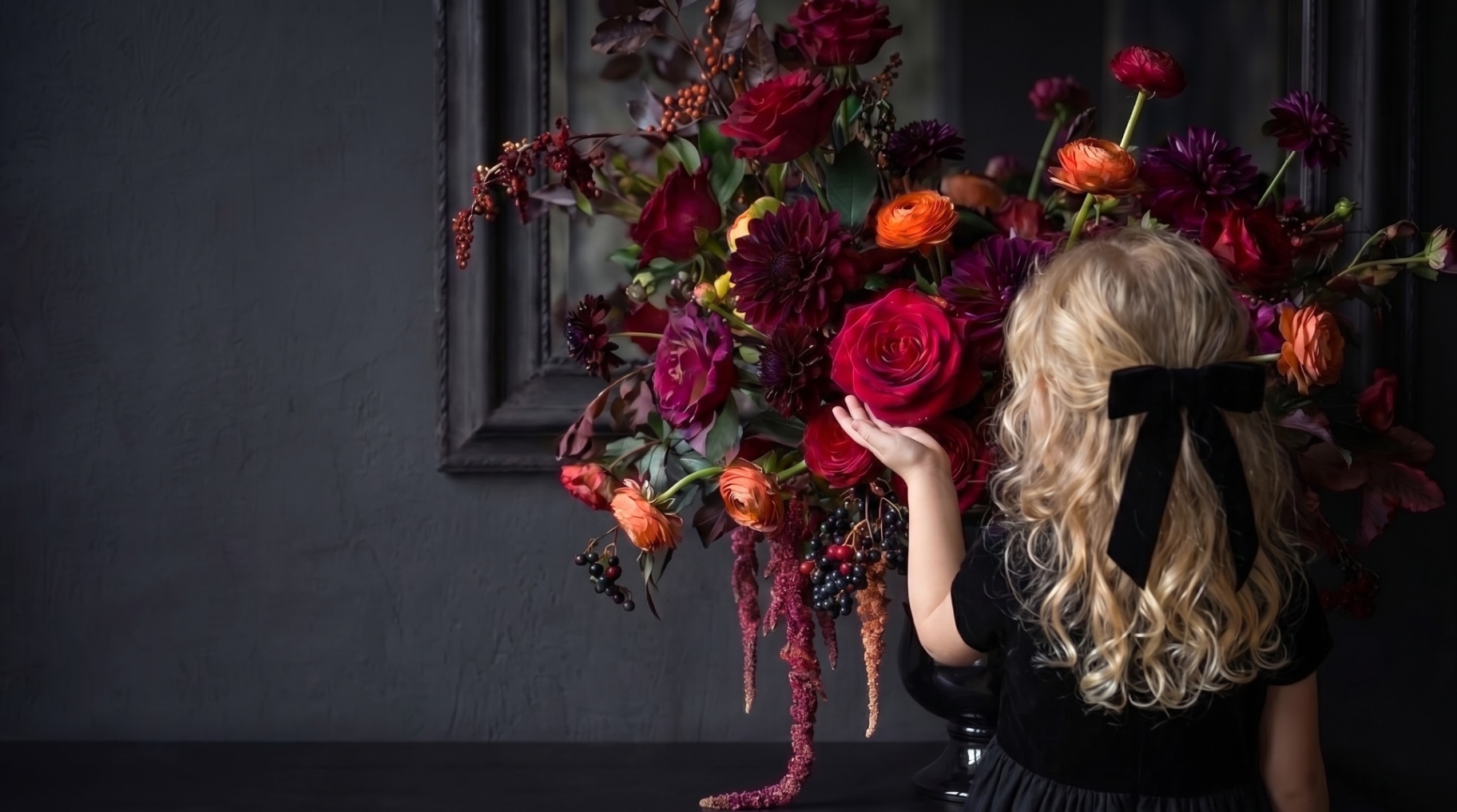 Girl reaching to a moody bouquet of roses